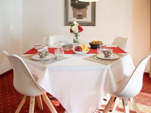a table with white chairs and a white table cloth at Apartment Chalet Abendrot apARTments-15 by Interhome in Grindelwald