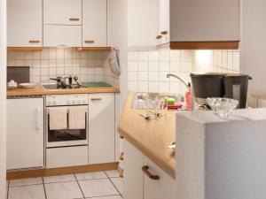 a kitchen with white cabinets and a sink at Apartment Chalet Abendrot apARTments-21 by Interhome in Grindelwald