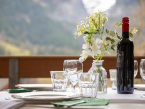 a table with a bottle of wine and glasses at Apartment Chalet Abendrot apARTments-21 by Interhome in Grindelwald
