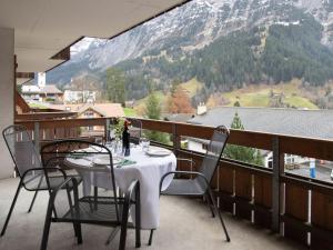 a table and chairs on a balcony with a view of a mountain at Apartment Chalet Abendrot apARTments-21 by Interhome in Grindelwald