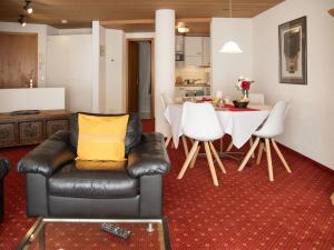 a living room with a leather couch and a table at Apartment Chalet Abendrot apARTments-15 by Interhome in Grindelwald