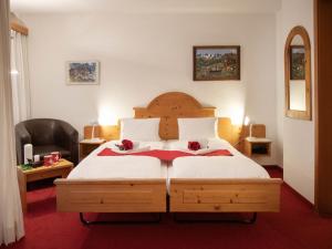 a bedroom with a bed with two flowers on it at Apartment Chalet Abendrot apARTments-2 by Interhome in Grindelwald