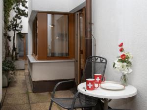 a table with two chairs and a table with red cups at Apartment Chalet Abendrot apARTments-2 by Interhome in Grindelwald