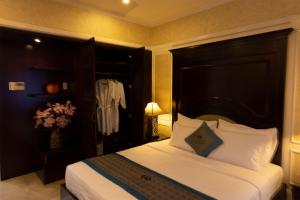 a bedroom with a large bed with a black headboard at Anpha Boutique Hotel in Ho Chi Minh City