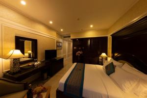 a hotel room with a large bed and a desk at Anpha Boutique Hotel in Ho Chi Minh City