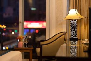 a lamp sitting next to a chair next to a window at Anpha Boutique Hotel in Ho Chi Minh City