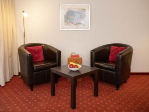 two chairs and a table with a bowl of fruit at Apartment Chalet Abendrot apARTments-7 by Interhome in Grindelwald