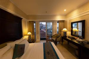 a hotel room with a bed and a desk and a window at Anpha Boutique Hotel in Ho Chi Minh City