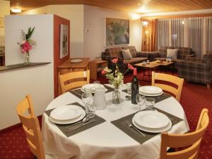 a dining room table with a white table cloth and a room at Apartment Chalet Abendrot apARTments-24 by Interhome in Grindelwald