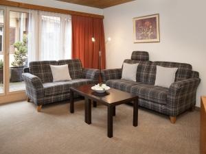a living room with two couches and a coffee table at Apartment Chalet Abendrot apARTments-20 by Interhome in Grindelwald