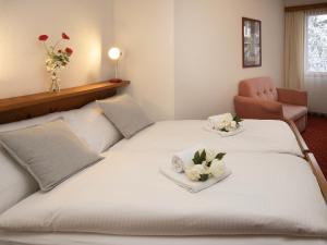 a hotel room with two beds with flowers on them at Apartment Chalet Abendrot apARTments-27 by Interhome in Grindelwald