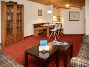 a living room with a table and chairs and a kitchen at Apartment Chalet Abendrot apARTments-27 by Interhome in Grindelwald