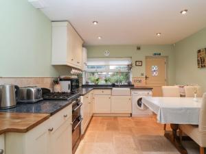 a kitchen with white cabinets and a counter top at Little Noo in Gloucester