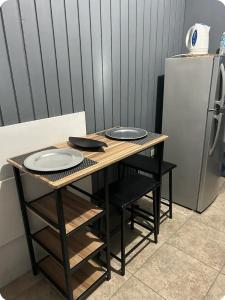 einen Holztisch mit zwei Tellern und einem Kühlschrank in der Unterkunft The Grayden Cottage in Kingston