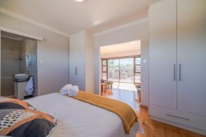 a bedroom with a large bed and a large window at Eagle's Wings - Exquisite mountain view Suite in Swellendam