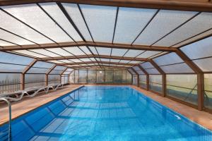 an indoor swimming pool with a glass roof at Cal Cirera in Sagás