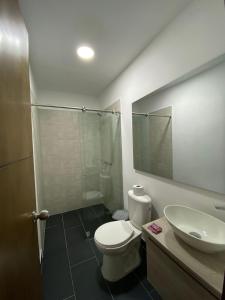 a bathroom with a toilet and a sink and a shower at Hotel Gallery By 70 in Medellín +29 photos