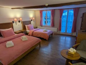 a hotel room with two beds and a couch at Hotel Schützen Lauterbrunnen in Lauterbrunnen