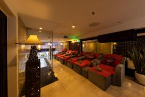 a living room with red couches and a lamp at Anpha Boutique Hotel in Ho Chi Minh City