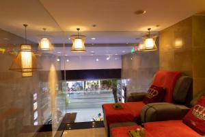 a living room with a red couch and a window at Anpha Boutique Hotel in Ho Chi Minh City