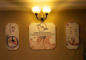 a sign hanging on a wall with three mirrors at Anpha Boutique Hotel in Ho Chi Minh City