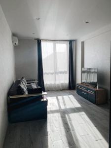 a living room with a couch and a television at Apartmets Domovik Мира 11с кв 7 Вместительная трёхкомнатная квартира in Mukacheve