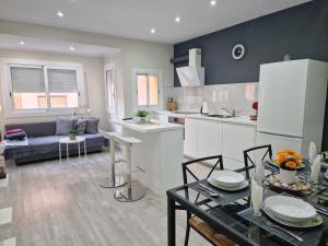 ロスピタレート・デ・リョブレガートにあるBarcelona 2 Habitacionesのテーブルと冷蔵庫のあるキッチンとリビングルーム