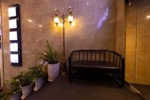 a bench in a room with plants and a light at Anpha Boutique Hotel in Ho Chi Minh City