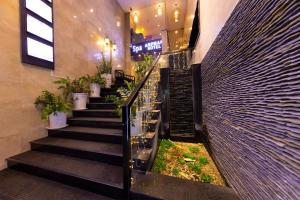 a lobby with stairs in a building with plants at Anpha Boutique Hotel in Ho Chi Minh City