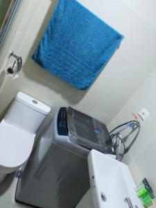 a blue towel is hanging on a wall next to a toilet at Fame Residences Tower 1 in Manila