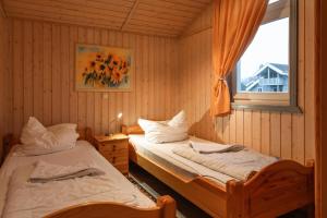 two twin beds in a room with a window at Seeschwalbe 54 in Rechlin