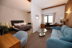 a living room with a blue couch and a bed at Hotel Radnice in Liberec