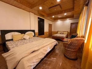 a bedroom with a bed and two chairs in it at Countryside Apple orchard by LivingStone in Shimla