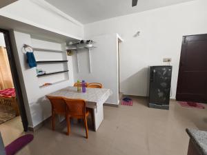a kitchen with a table and chairs in a room at ZTRIO Vacations in Chikmagalūr