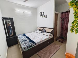 a small bedroom with a bed and a mirror at ZTRIO Vacations in Chikmagalūr