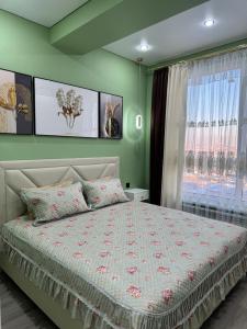 a bedroom with a large bed and a window at Luxury apartments Capital City in Shymkent +13 photos