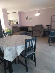 a living room with a table and chairs and a couch at Bathy Ház in Tiszakécske +10 photos