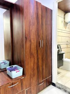 a wooden cabinet in a bathroom with a shower at Mochastay in Dehradun