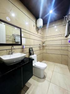 a bathroom with a sink and a toilet and a mirror at Mochastay in Dehradun