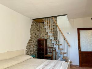 a bedroom with a staircase with a stone wall at Casa a Chiocciola - Scurano in Scurano +8 photos