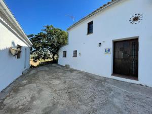 ein großes weißes Gebäude mit einer Auffahrt daneben in der Unterkunft Casa de Campo Cortijo Madrigueras in Algodonales
