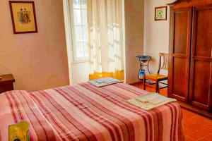 una camera da letto con un letto con una coperta a righe e una finestra di Agriturismo Morisfarms - Santa Chiara a Massa Marittima