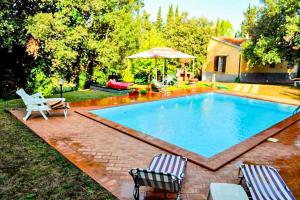 una piscina con due sedie e un ombrellone di Agriturismo Morisfarms - Santa Chiara a Massa Marittima Altre 11 foto
