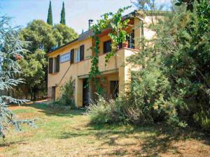 un grande edificio giallo con alberi di fronte di Agriturismo Morisfarms - Santa Chiara a Massa Marittima