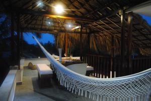 a hammock in a hut with a boat in it at Rincón del mar Veleros Hotel in San Onofre