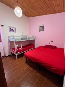 a bedroom with a red bed and a bunk bed at Villa Cristina in Santa Caterina