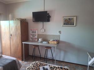 a small table with two stools in a room at Schweizer Guesthouse in Schweizer-Reineke