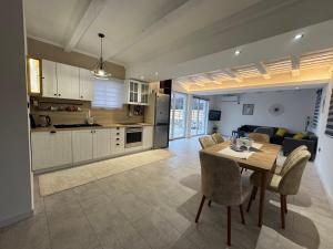 a kitchen and living room with a table and chairs at Village Pool Villa Silentium in Mostar