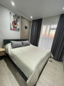 Un dormitorio con una cama grande y una ventana. en HERMES Cityview Apartment, en Chişinău