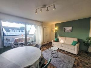 a living room with a table and a couch at Apartment Les Embruns-1 by Interhome in Carnac